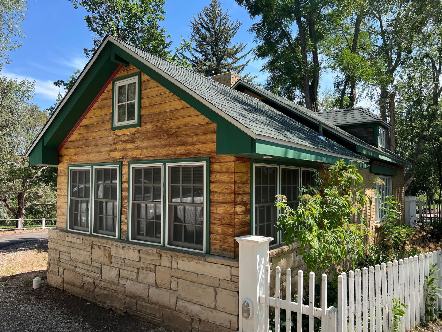 Historic cottage before painting wood siding green trim