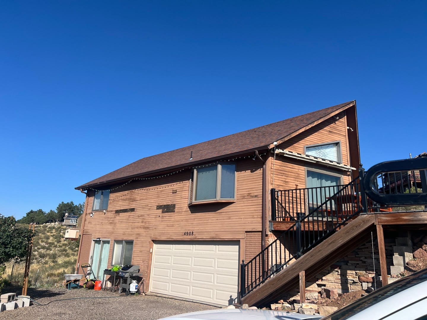 Hillside home before exterior painting natural wood siding
