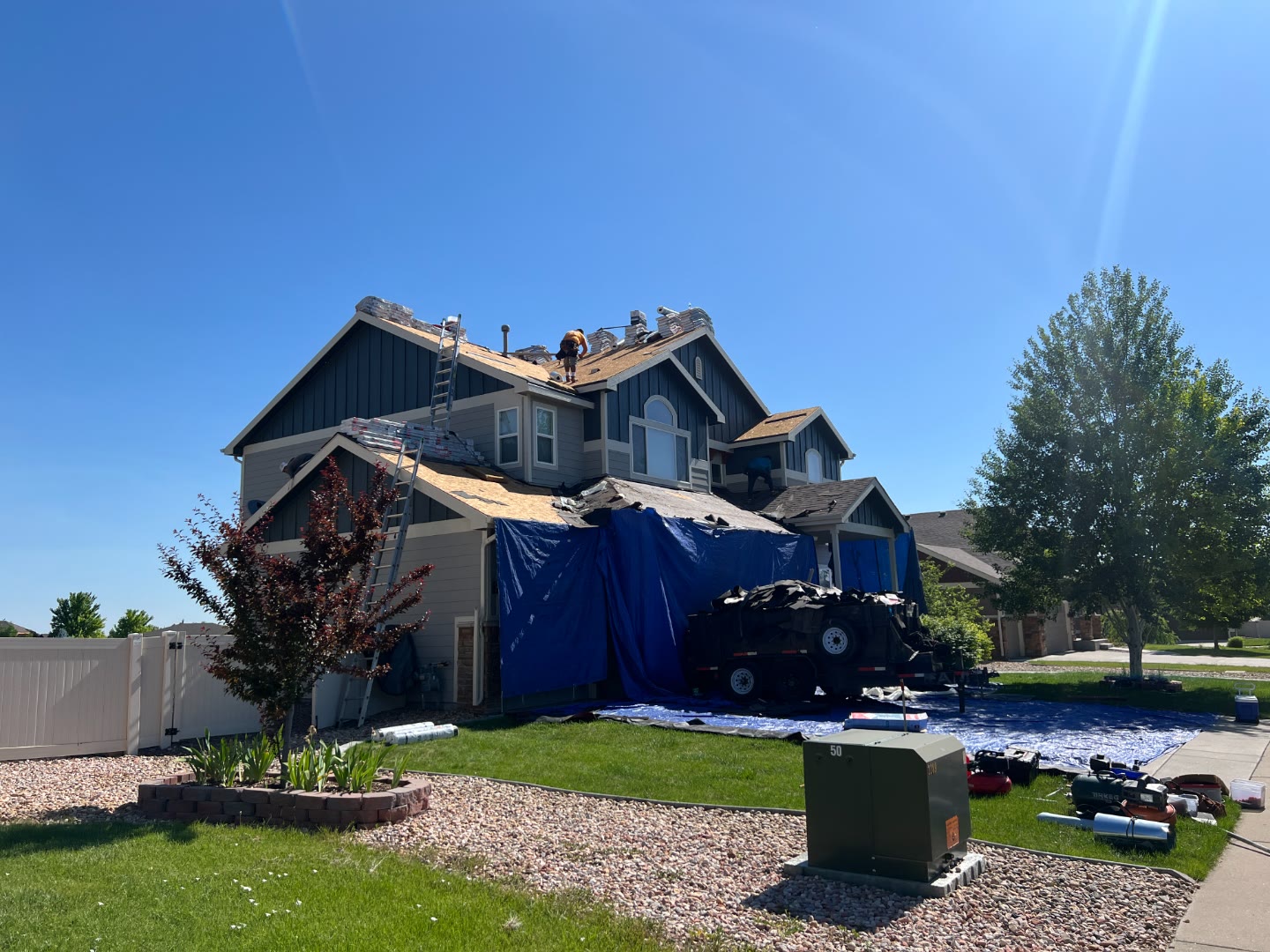 Two-story home roof tear-off before new shingles Fort Collins